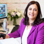 Marie at desk with computer and phone